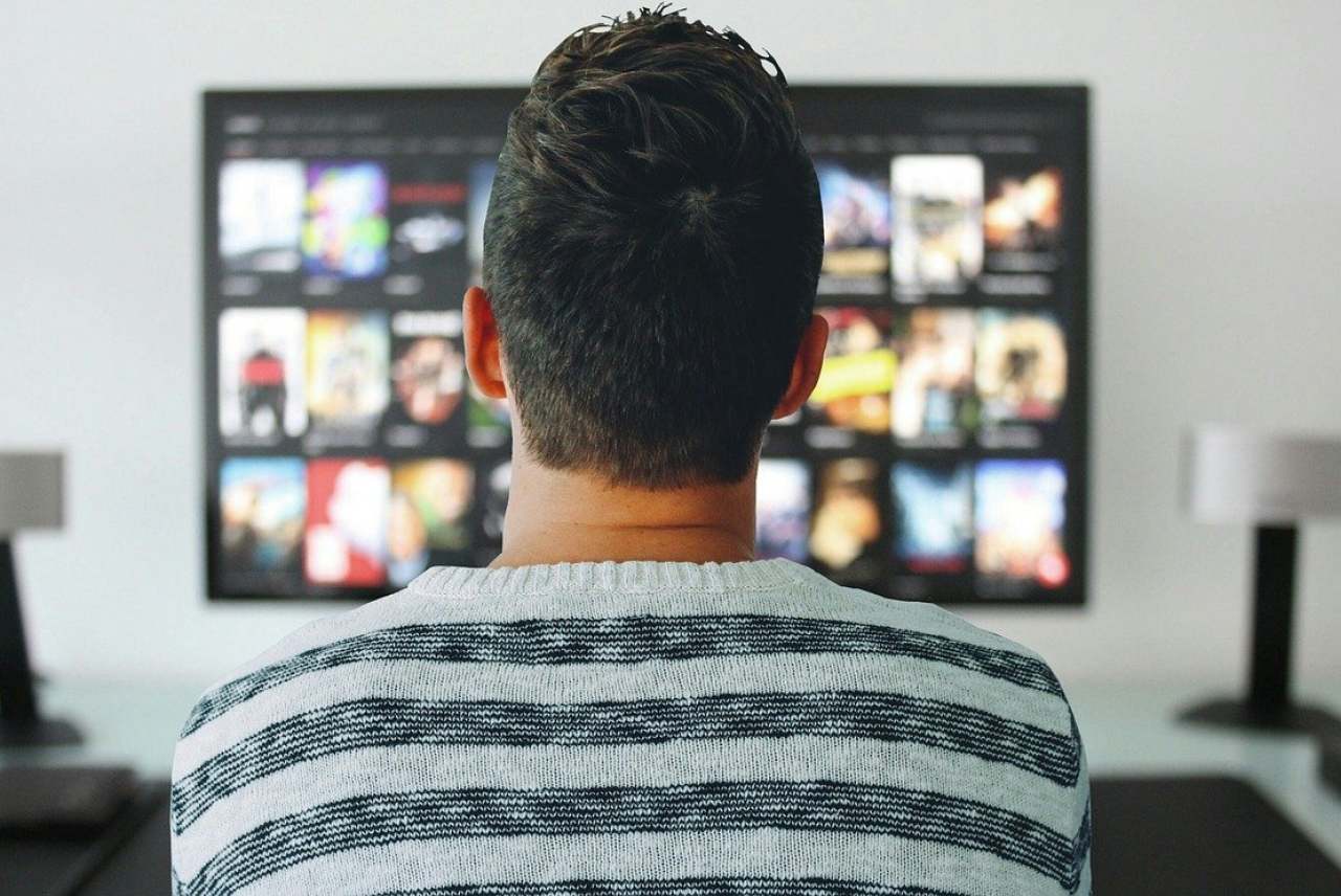 View of back of man watching television