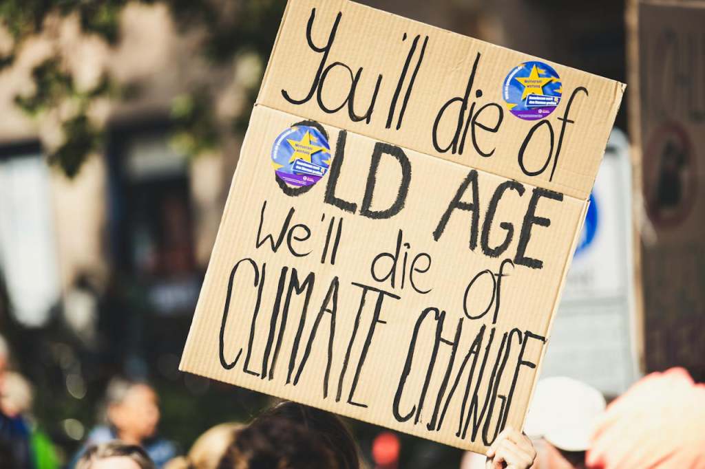 Climate change protest with placard "you'll die of old age, we'll die of climate change"