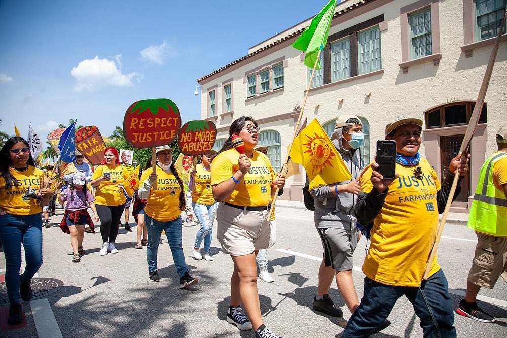 People in yellow t-shirts which read 'Justice for Farm Workers'
