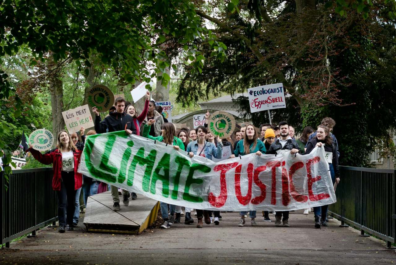 Group of climate justice protesters with banners and placards
