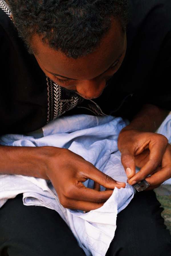 Person sitting and mending clothes