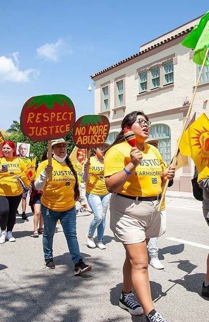 People in yellow t-shirts which read 'Justice for Farm Workers' on protest march